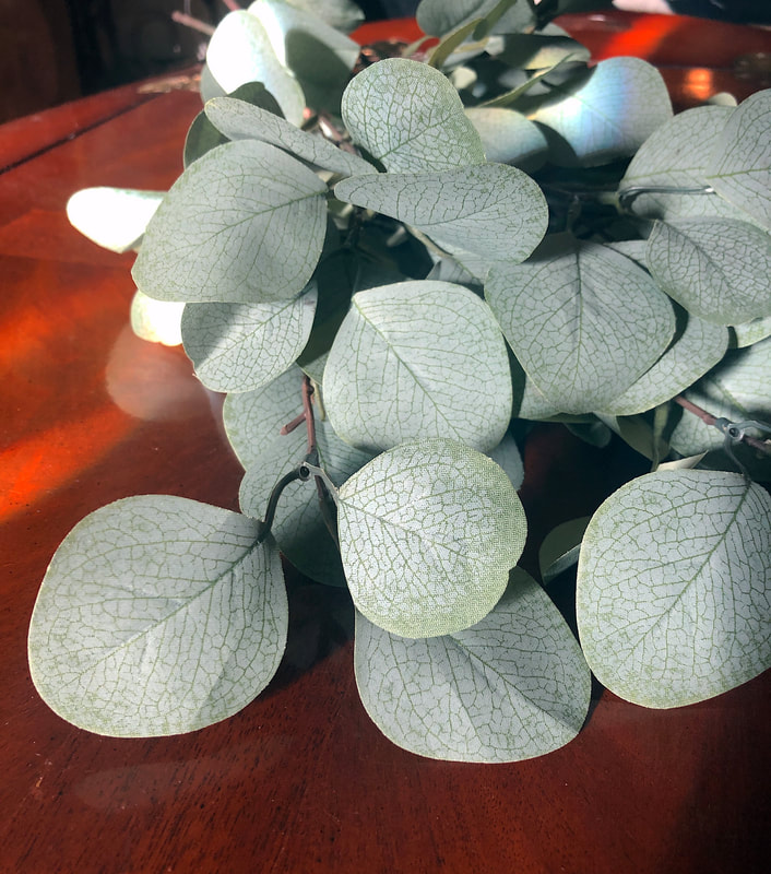 Faux eucalyptus leaves on a table.