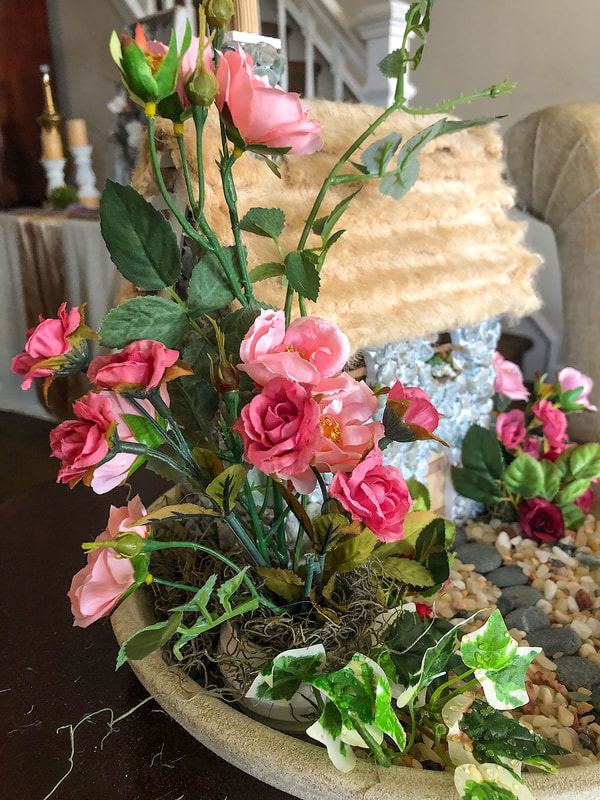 Faux mini roses in an indoor fairy garden.