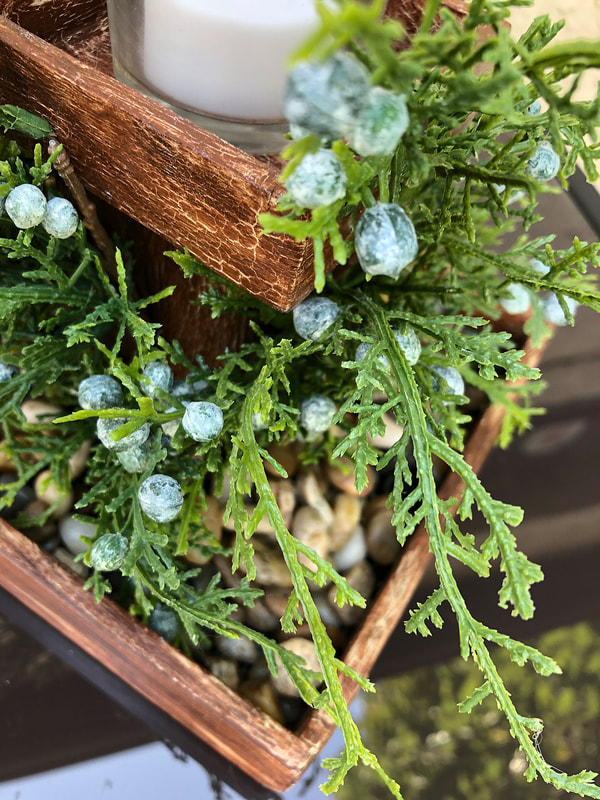Faux juniper on a handcrafted candkeholder closeup.