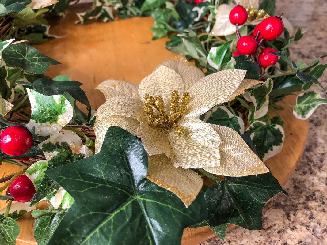 DIY faux ivy vine wreath with red berries and gold poinsettias.