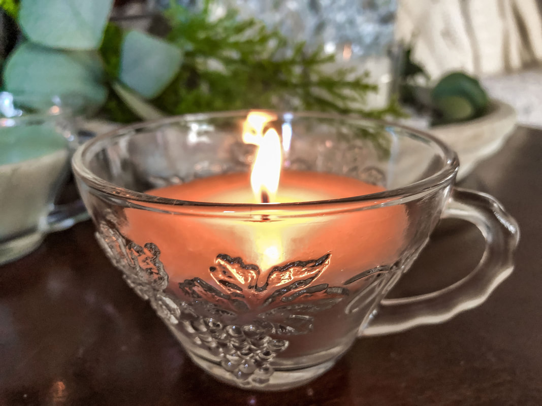 Burning a homemade candle in a glass tea cup