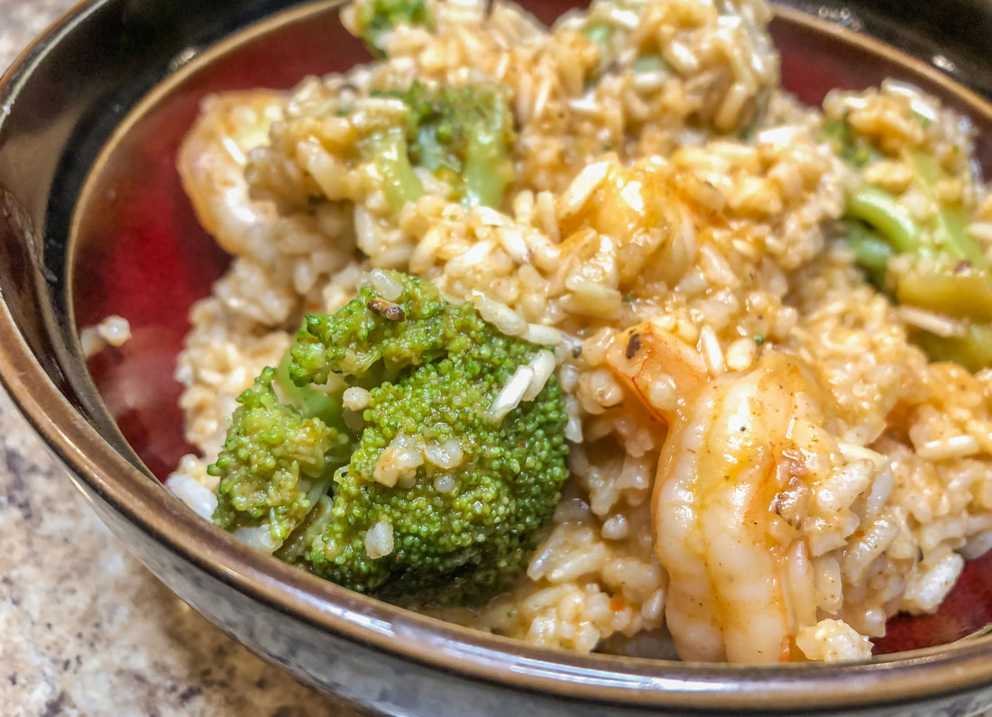 Spicy shrimp and broccoli with rice in a bowl closeup.