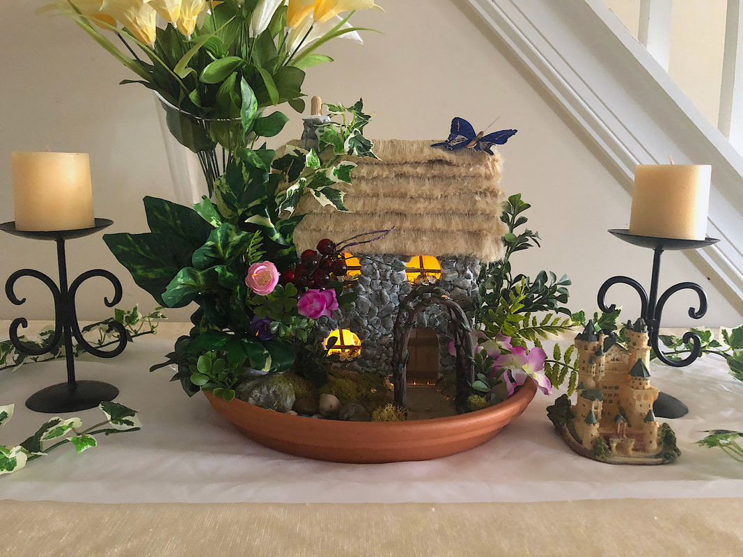 Indoor spring themed fairy garden with handcrafted English Cottage.