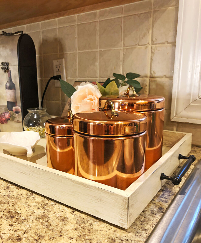 Copper tins displayed on a DIY coffee and wine bar on kitchen counter.