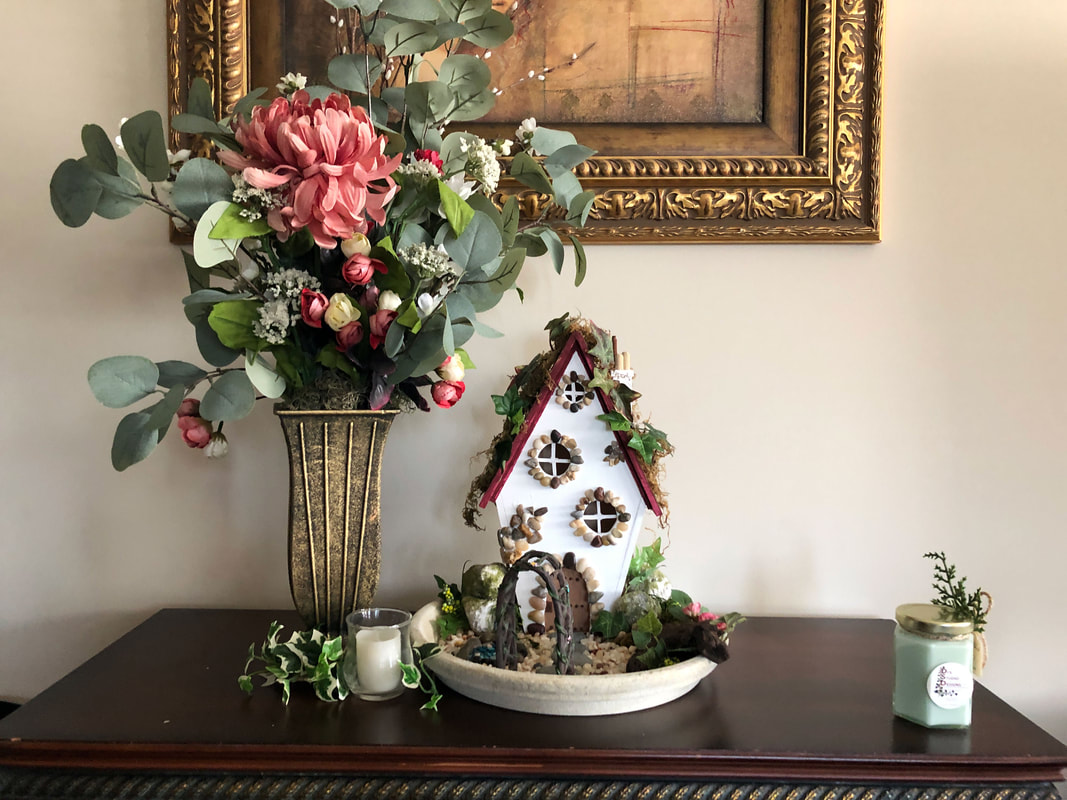Vignette with indoor fairy garden and handcrafted fairy cottage.