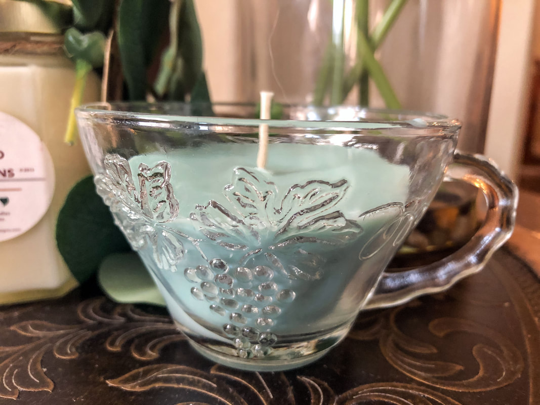 Homemade soy candle with eucalyptus scent in a glass tea cup. 