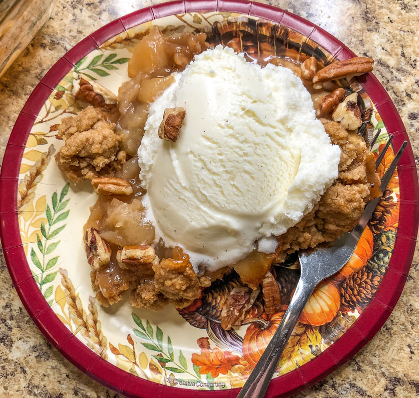 Apple crumble dessert with pecans and vanilla ice cream.