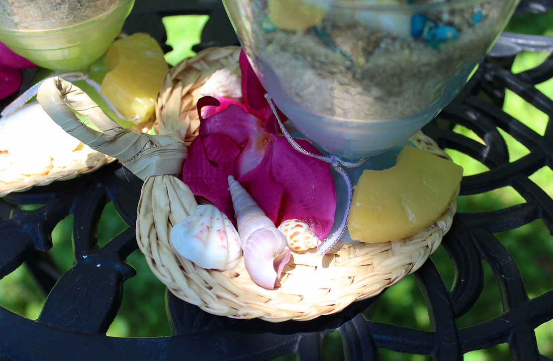Repurposed dessert glass with faux florals and tropical decor.