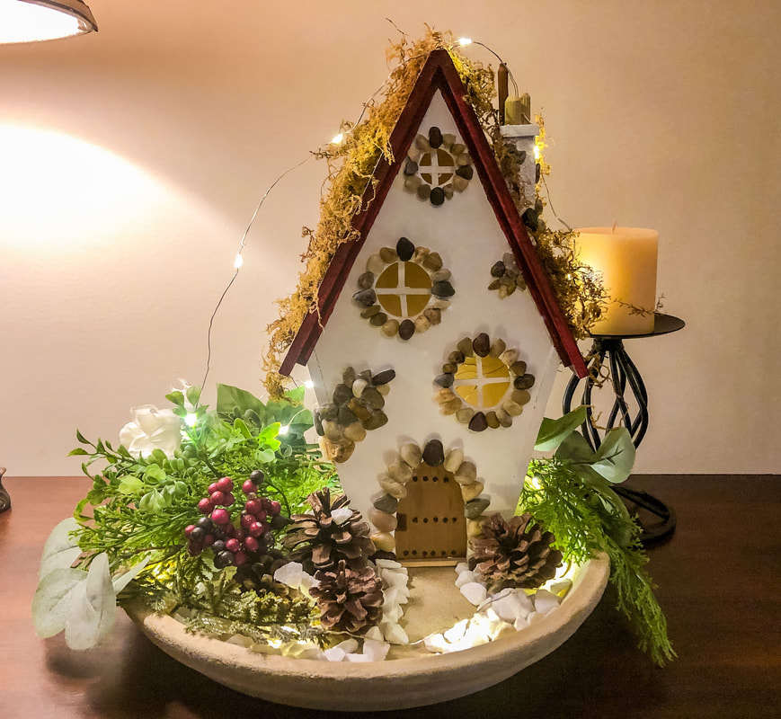 Handcrafted fairy cottage and indoor fairy garden with faux floral winter decor.