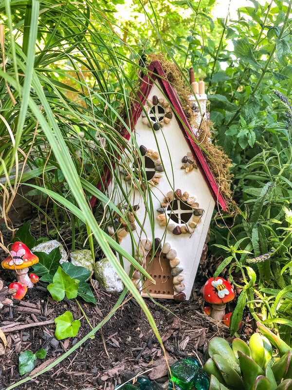 Outdoor fairy garden featuring handcrafted fairy cottage.