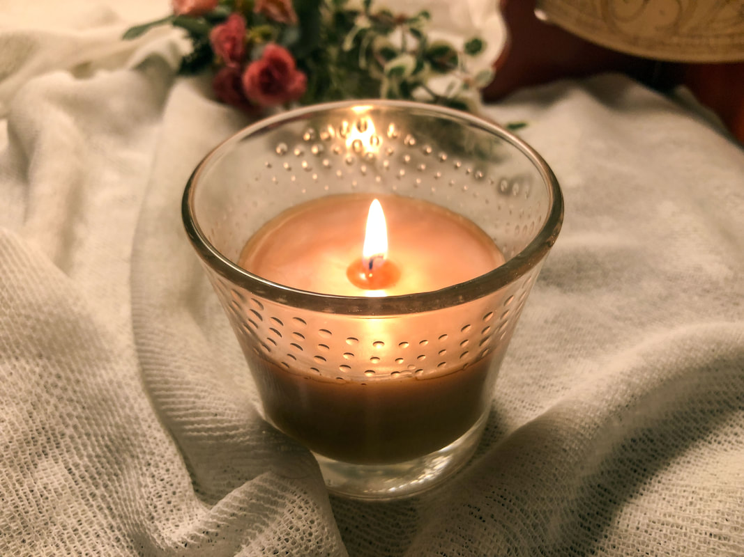 Scented candle burning to provide pleasant fragrance in a room.