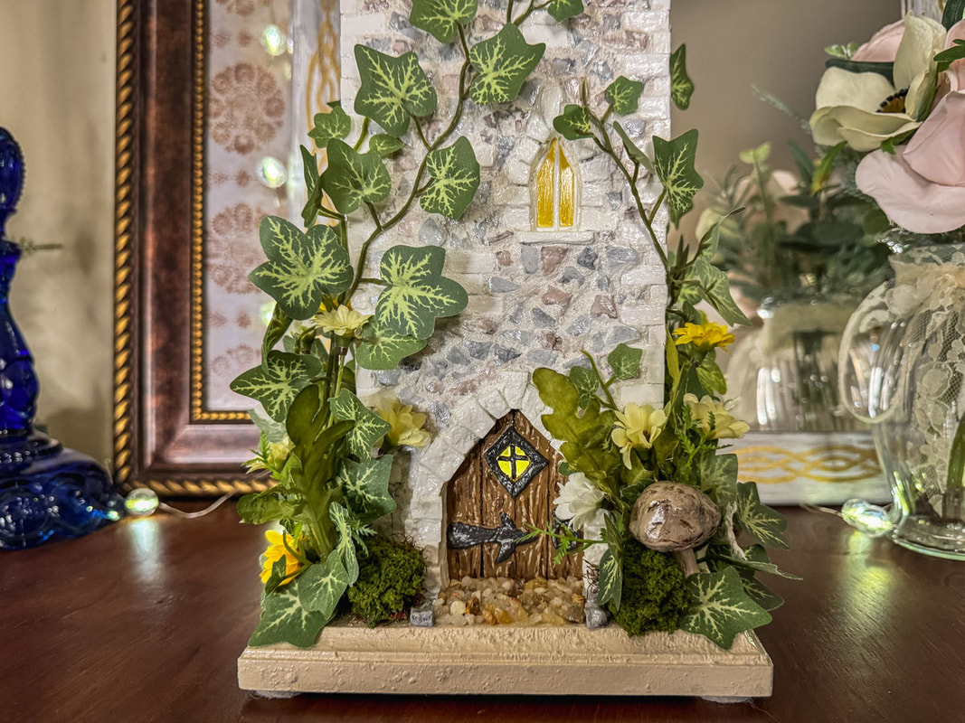 Closeup view of a handcrafted fairy castle entrance with ivy.