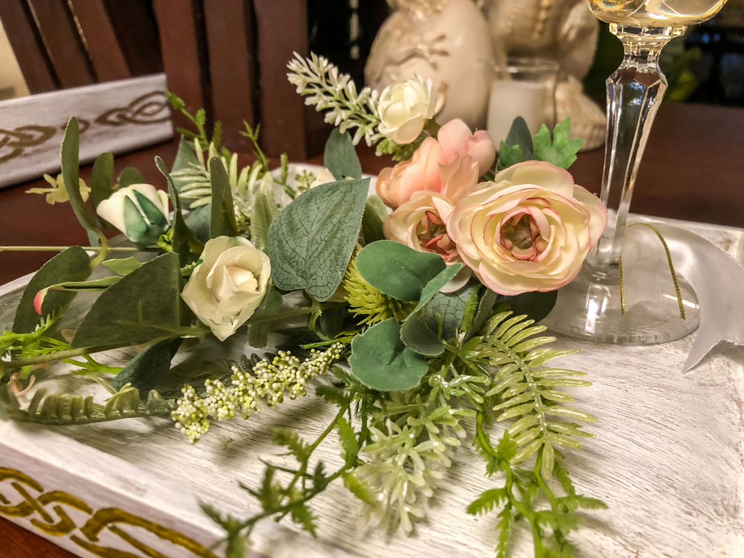 Faux florals in a handcrafted tray and up-cycled stemware.