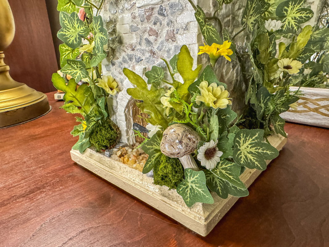Closeup of a miniature castle door with faux florals.