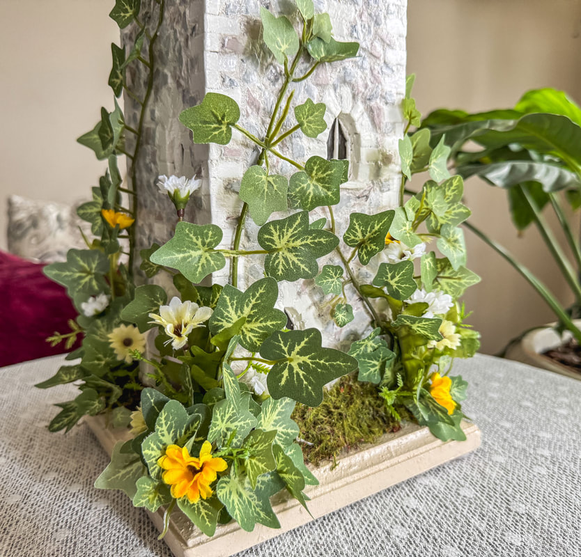 Faux ivy on a miniature handcrafted castle tower.
