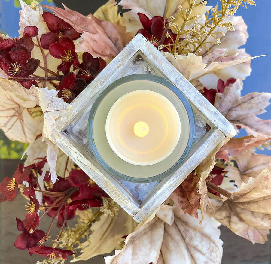 Top of handcrafted fall candle holder with faux florals.